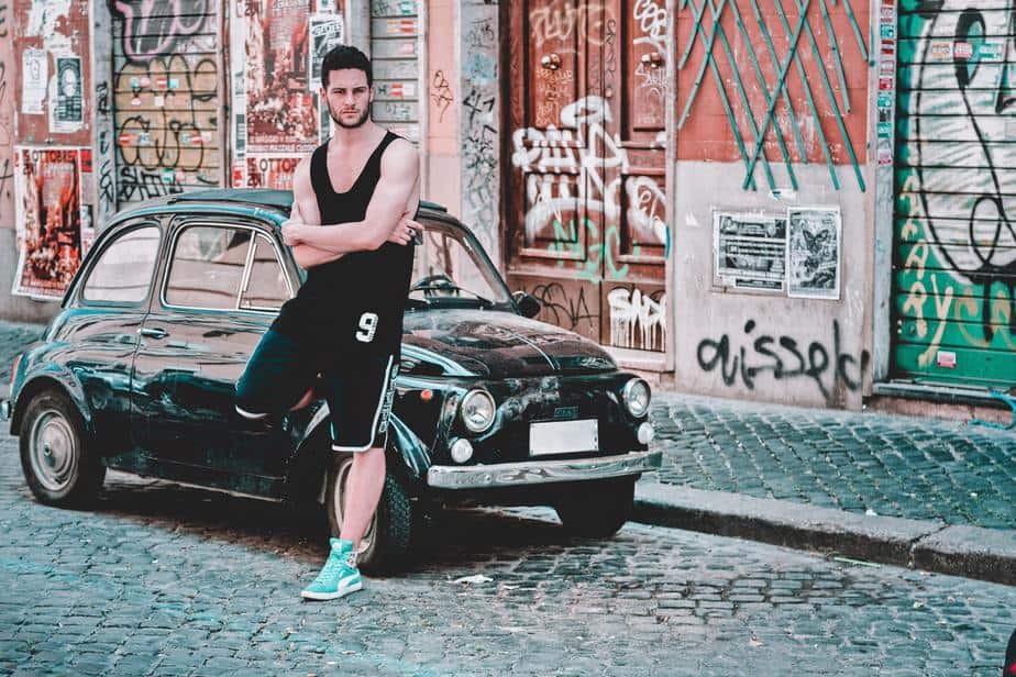 young-man-leaning-on-car-street-graffiti